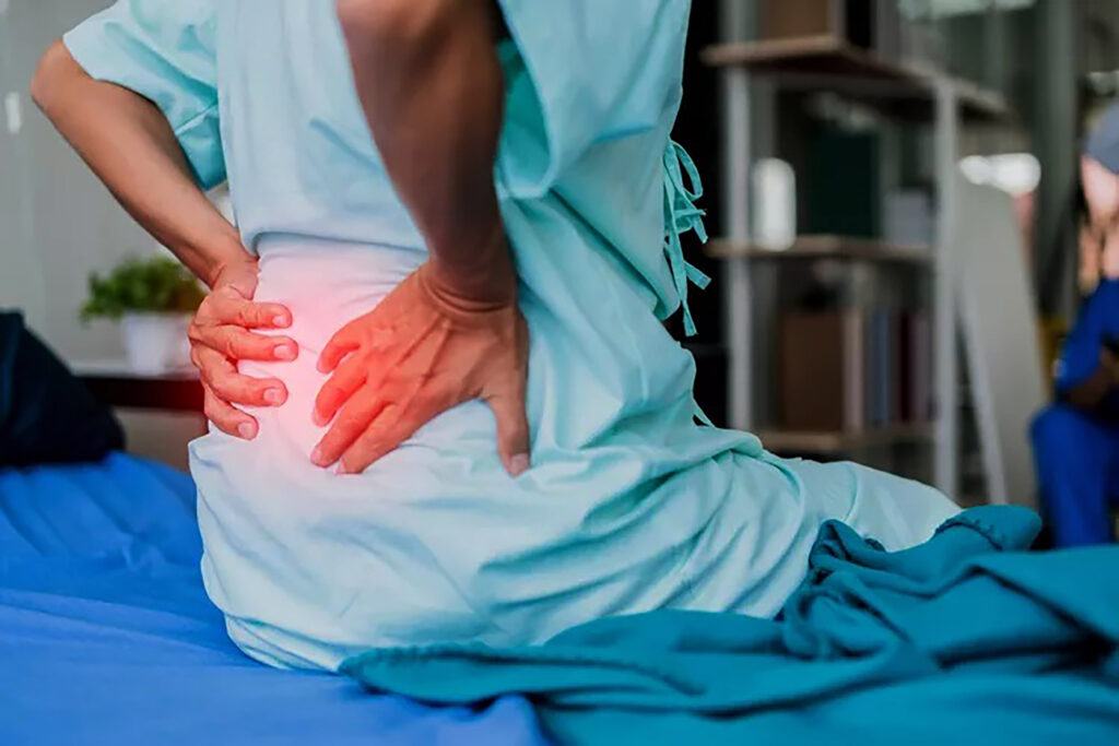 Midsection of Patient Suffering from Backache on Bed in Hospital